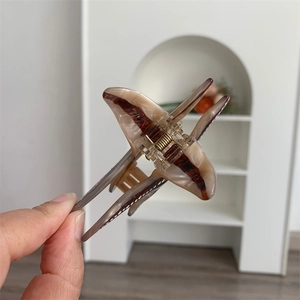Détail d'une pince à cheveux motif écaille de tortue avec ressort en métal doré