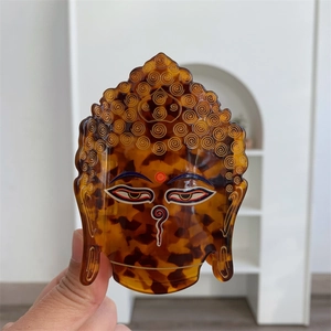 Détail macro d'une pince à cheveux tête de bouddha en acétate avec motif écaille