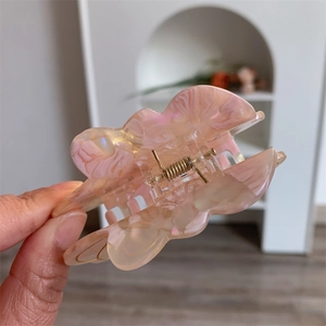 Detailed view of pink pearlescent flower hair claw clip made of acetic acid material