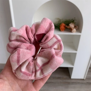 Détail du chouchou à carreaux rose et blanc en tissu de laine doux et épais