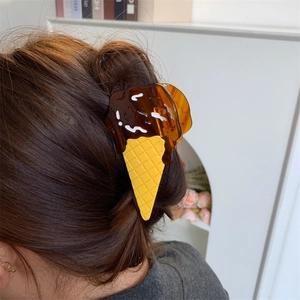 Detail of ice cream cone hair claw clip with chocolate scoop on brown hair