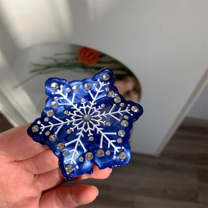 Vue détaillée d'une pince à cheveux flocon de neige bleu foncé avec strass brillants