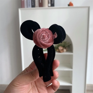 Detailed close-up of a vintage black velvet flower hair claw clip with a large rose design