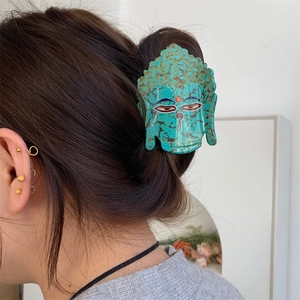 Détail de la pince à cheveux tête de Bouddha turquoise avec accents dorés sur modèle