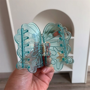 Detail of a translucent teal butterfly hair claw clip with starfish and shell patterns