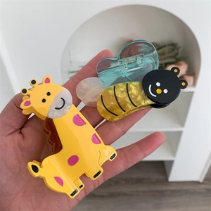 Detail of cartoon giraffe and bee hair claws made of marble textured acetate material