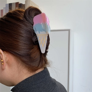 Detail view of pink and blue acetate hair claw clip styled on a model hair bun