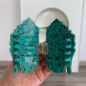 Détail de la pince à cheveux en acétate avec motif marbre turquoise et ressort métallique