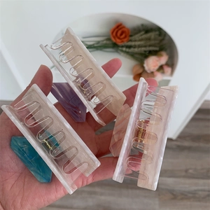 Close-up of colorful large acetate hair claws with marble texture and gold springs
