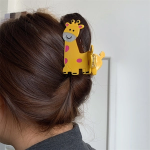 Detailed view of the yellow giraffe acetate hair claw clip worn on brunette hair