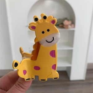 Close-up of a cartoon giraffe hair claw clip made of smooth yellow and pink acetate