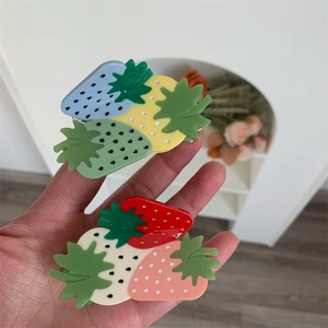 Detail of colorful strawberry claw clips in acetate resin with smooth polished surface