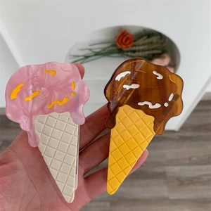 Detailed view of hair claws in pink strawberry and brown chocolate ice cream cone design