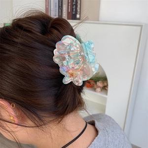 Detailed view of ocean theme marble shell hair claw with pearls and starfish on model hair