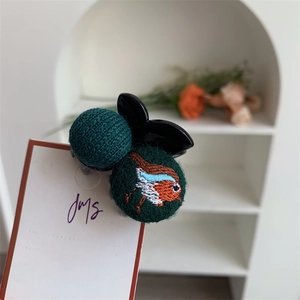 Close-up of bird embroidery and knitted texture on creative cartoon hair clip