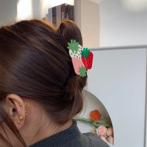 Detail of sweet strawberry hair claw clip with red and pink fruit on hair for women