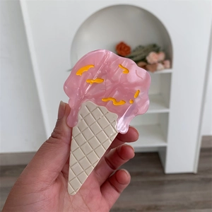 Detail view of an ice cream cone hair claw clip with pink acetate and waffle texture