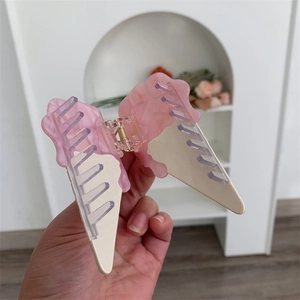Detailed view of pink and cream acetate hair claw clip in a melting ice cream design