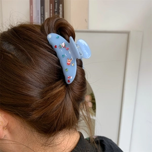 Vista dettagliata di un fermaglio per capelli azzurro con motivi natalizi di orsi e cervi