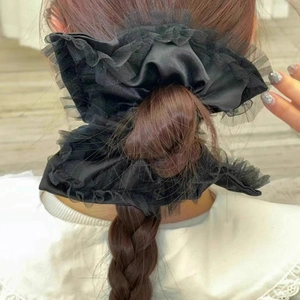 Elegant black satin scrunchie with lace trim edges shown on a ponytail hair style