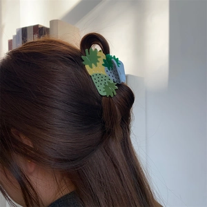 Detail showing high-quality acrylic strawberry hair claw clip worn in a half-up hairstyle
