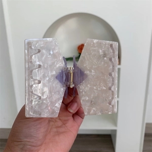 Macro shot of large marble texture acetate hair claw clip with purple hinge and gold spring