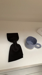 Detailed view of a large black satin bow hair clip featuring elegant vintage fabric texture