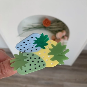 Detailed close-up of a medium acrylic shark clip with colorful strawberry motifs