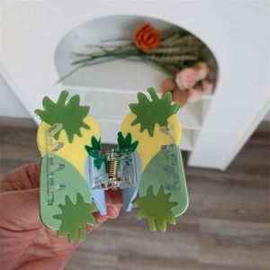 Close-up of yellow and green pineapple claw clip with high-quality metal spring