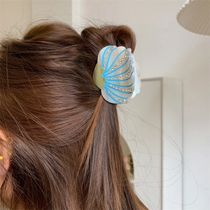 Detail of shell hair claw with blue stripes and crystals on model for half-up hair