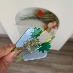 Close-up of blue and green strawberry shark hair claw clip made of glossy acrylic material