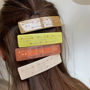Lot de quatre barrettes en acétate brillant aux tons chauds avec détails en strass