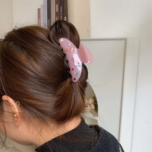 Dettaglio della molletta natalizia con strass colorati su resina acetato rosa chiaro