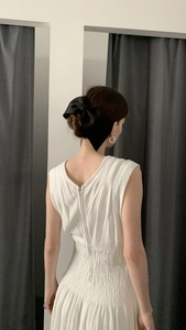 Elegant large black satin bow hair clip worn on a low bun hair style for women