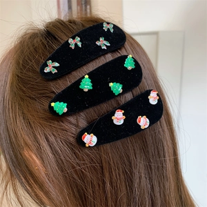 Detail view of festive Christmas hair clips with snowman and tree on brown hair