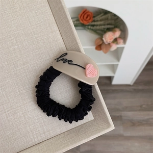 Chouchou élégant en tissu avec charm cœur LOVE en acrylique sur plateau lin