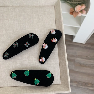 Close-up of Christmas BB hair clips featuring snowman, Xmas tree and festive bow accessories