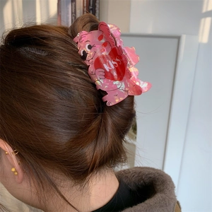 Detail view of pink bear hair claw clip with heart and KISS text on hair bun