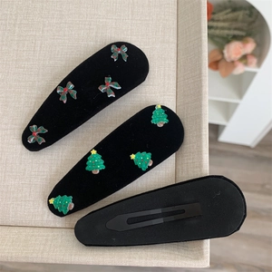 Close-up of Christmas BB hair clips featuring red green plaid bows and mini trees
