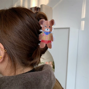 Detail of cute bear hair claw clip with colorful laser finish on brown hair bun