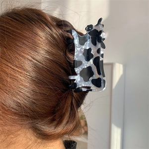 Dettaglio del fermaglio per capelli con motivo a mucca in acrilico lucido sui capelli