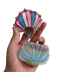 Shell-shaped acetate hair clips with rhinestones and colorful wave patterns