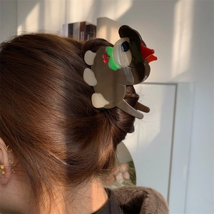 Détail de la pince à cheveux canard marron kaki portée avec des accents rouges et verts