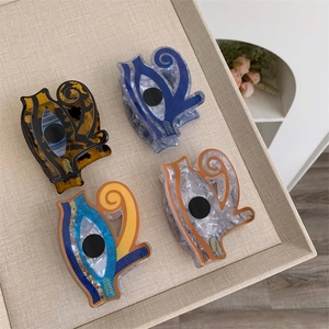 Set of four acrylic evil eye water bottle shape hair claws in tortoise and marble patterns