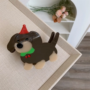 Détail macro de la pince à cheveux teckel en acétate avec bonnet de Noël et écharpe