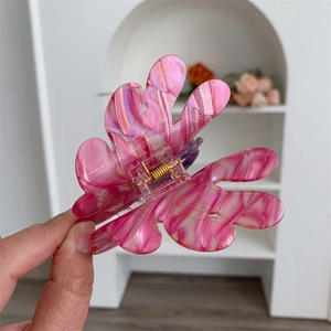 Detail of butterfly hair claw clip with pink and purple marble texture finish