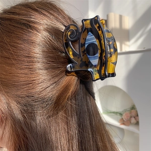 Acrylic hair claw clip with evil eye pattern on tortoise shell finish for half-up hair