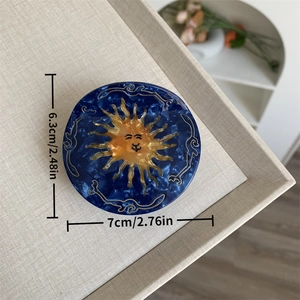 Detail of 7cm celestial acetate hair claw with blue marble texture and sun face motif