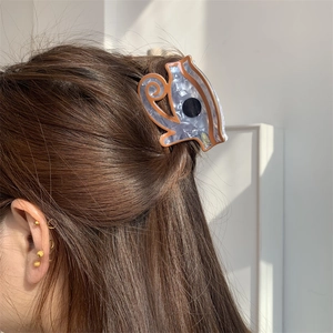 Detail view of purple marbled acetate hair claw clip in a cute squirrel shape on hair