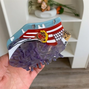 Dettaglio della pinza per capelli in acetato colorato con un motivo artistico a fumetti